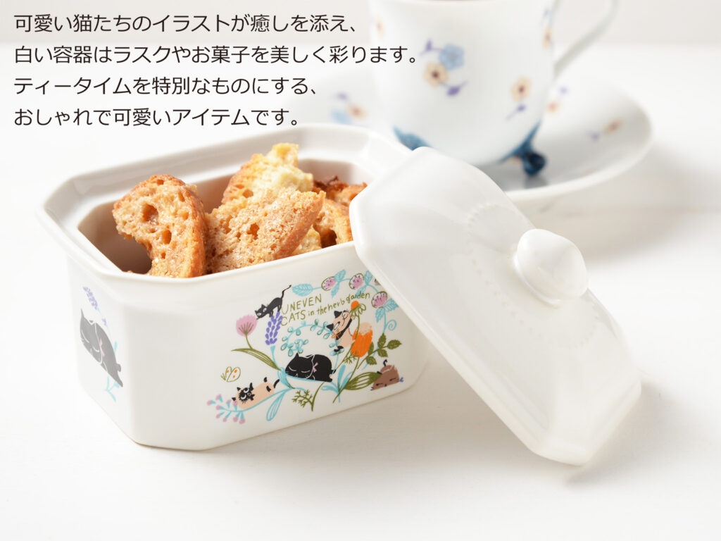 雑貨デザイナーシンジカトウさんが可愛い猫のイラストを白い陶磁器製の蓋物の陶磁器にデザインした食器のイメージ画像です。