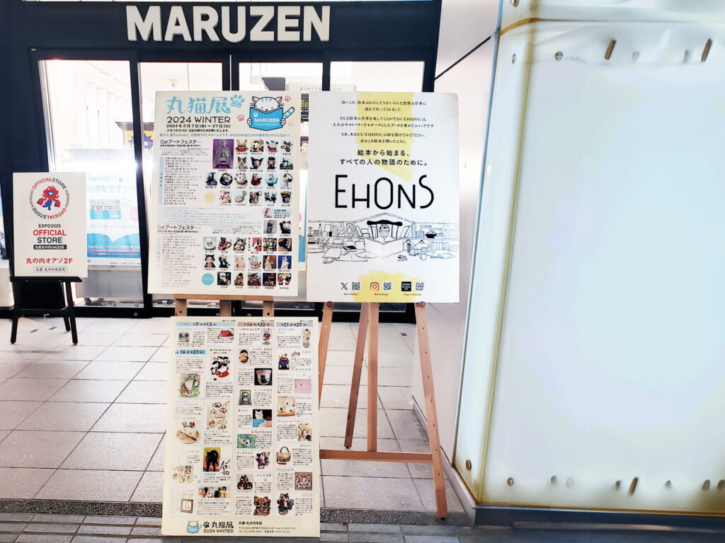 東京、丸善丸の内本店で開催の「丸猫展」の看板が丸善丸の内本店の入口に掲載の様子を写真に撮った画像