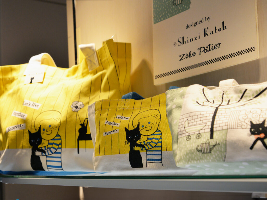 雑貨デザイナーシンジカトウさんの人気の猫のイラストが描かれた帆布の生地のバッグの画像