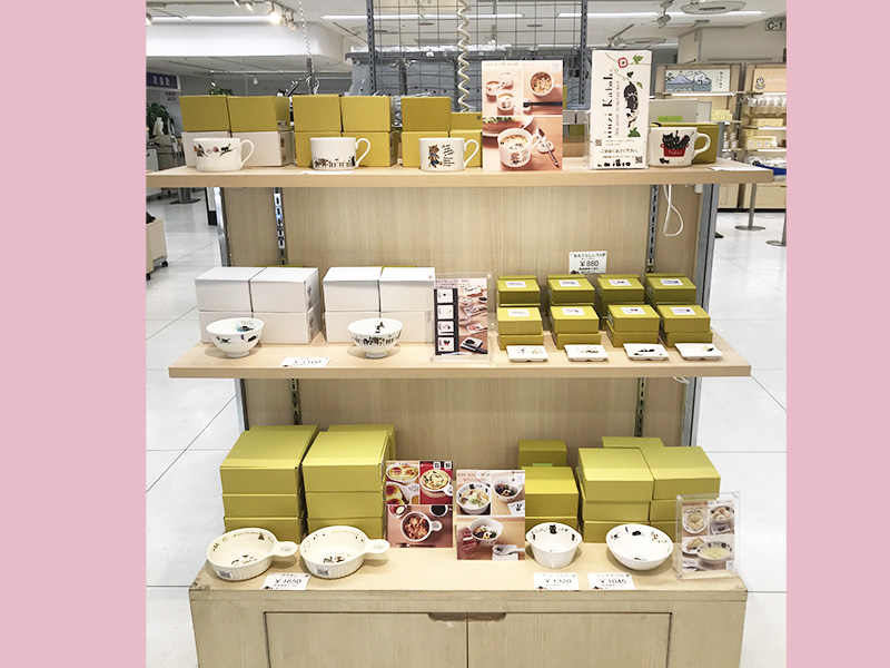 東武百貨店池袋店で開催中のてらねこ写真展での物販コーナーで雑貨デザイナーシンジカトウさんデザインのかわいい猫が描かれたゼルポティエの食器を販売している様子