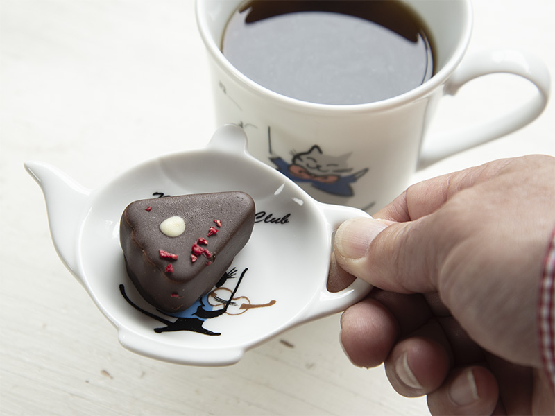 ネコトモクラブシリーズのティートレー、小皿にチョコレートのお菓子をのせてマグカップと一緒にティータイムを楽しむ様子の画像です。