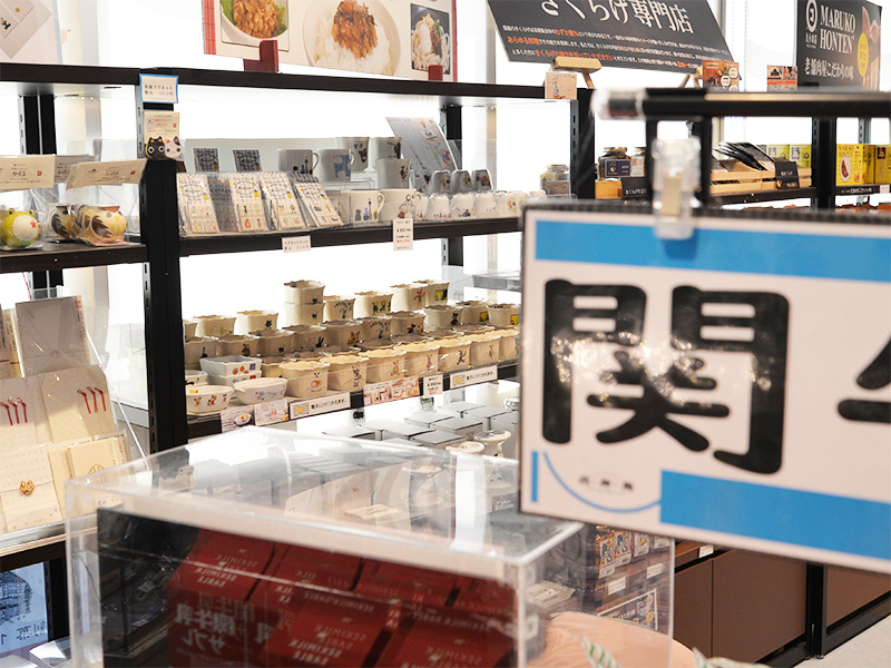  サービスエリア売店の広々とした店内。手前にはお土産の箱が山積みにされており、奥の棚には様々な食品や雑貨、そして「きくらげ専門店」の看板が見えます。