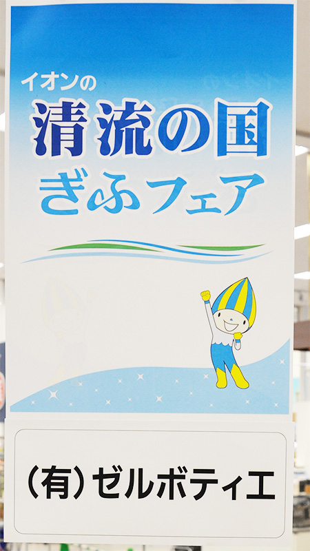 イオンの「清流の国ぎふフェア」と書かれた、青い大きな立て看板。下部には「(有)ゼルポティエ」と書かれている。