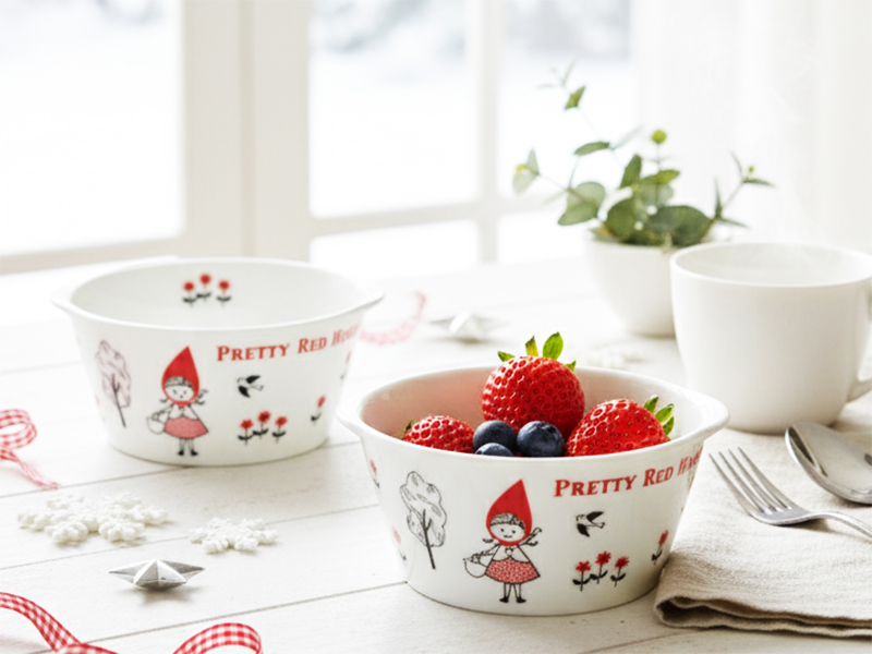 赤ずきんちゃんのイラスト入りボウル2個にベリー類を入れ、白いテーブルに置かれた明るい食卓風景。シンジカトウデザインの赤ずきんちゃんカフェココットに盛り付けた、イチゴとフレンチトーストの可愛い食卓。モレラ岐阜 蚤の市出品。