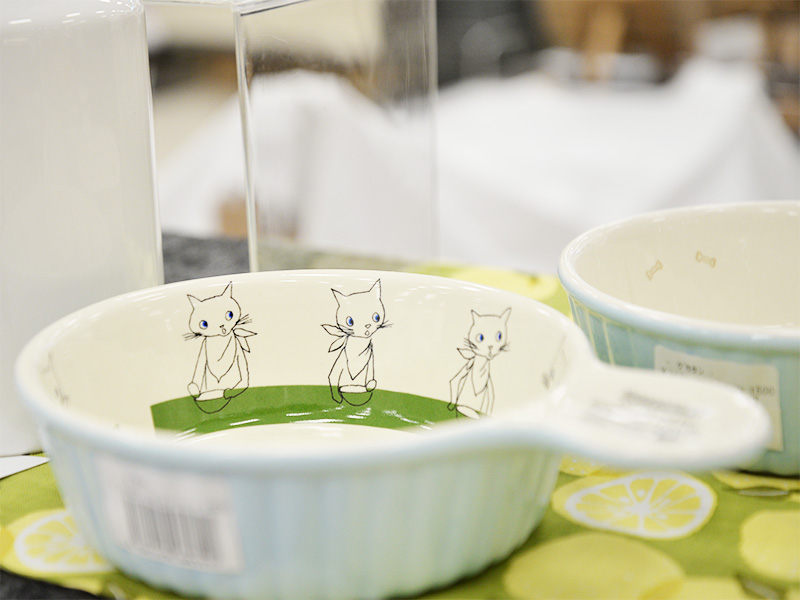 水色の縁に3匹の白い猫のイラストが描かれた、持ち手付きの可愛らしい白いグラタン皿。