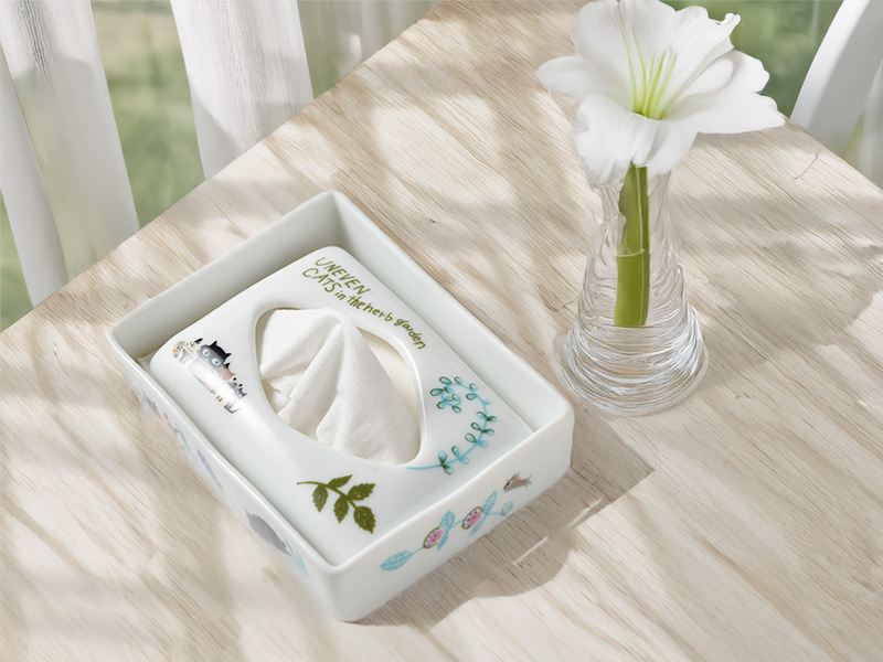 猫のイラストが描かれた白い陶器製ティッシュケースカバーと、白い花の一輪挿し。可愛い猫のイラストが描かれた陶器製ティッシュケース。インテリア雑貨。シンジカトウ。