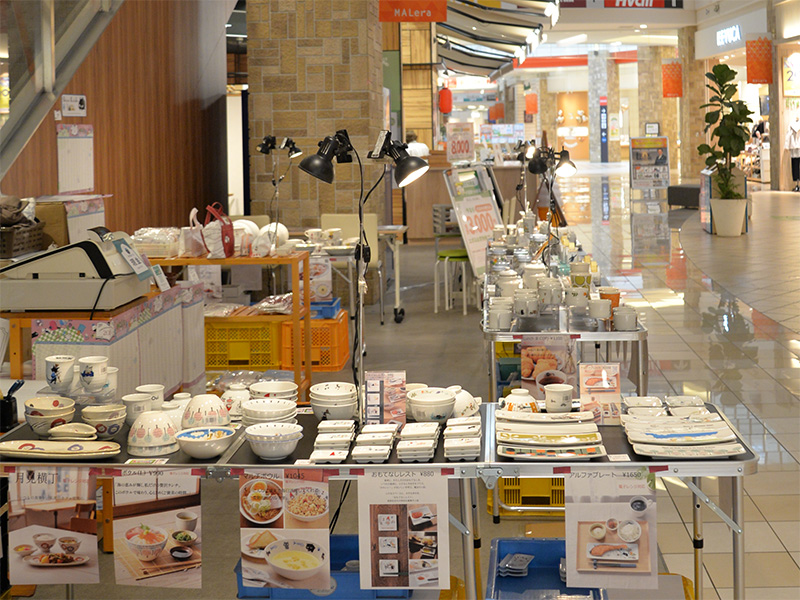 【会場の雰囲気】広々としたモレラ岐阜の通路。商品が陳列されたテーブルが並び、多くのお客様を迎え入れる準備が整っている様子。