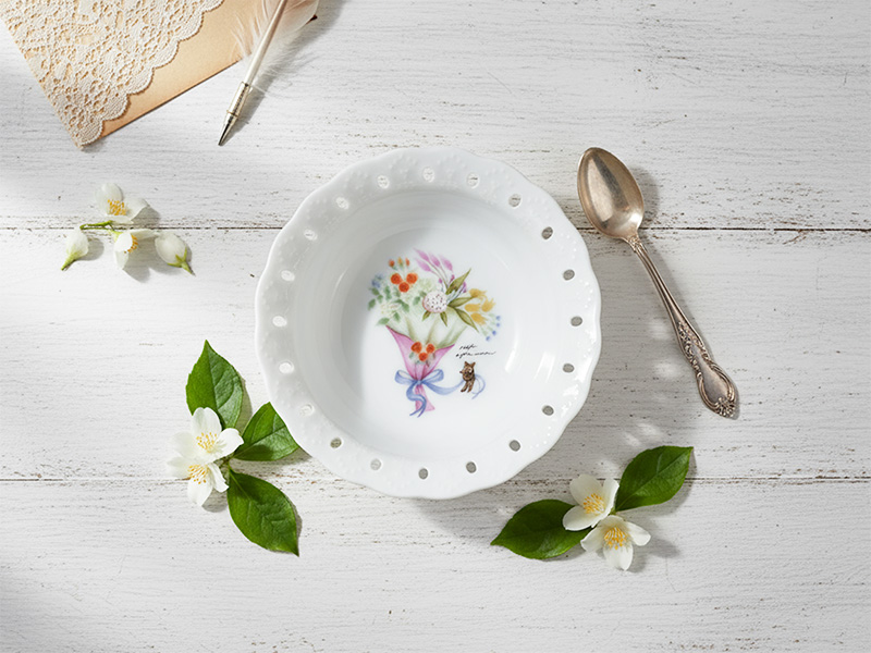 ソフトアフタヌーンのフリルボウルを白い板の上に置いた写真。花束のデザインとレースのようなフチが上品な印象。