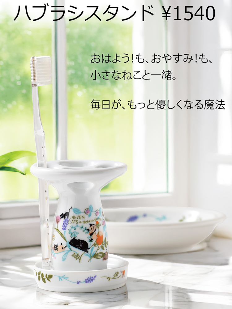 ハブラシスタンド, 美濃焼, シンジカトウ, 猫グッズ　シンジカトウデザインの愛らしい猫柄が描かれた美濃焼のハブラシスタンド。明るい窓辺に置かれ、ハブラシが一本立てられている。「ハブラシスタンド ¥1540」とキャプションが表示されている。