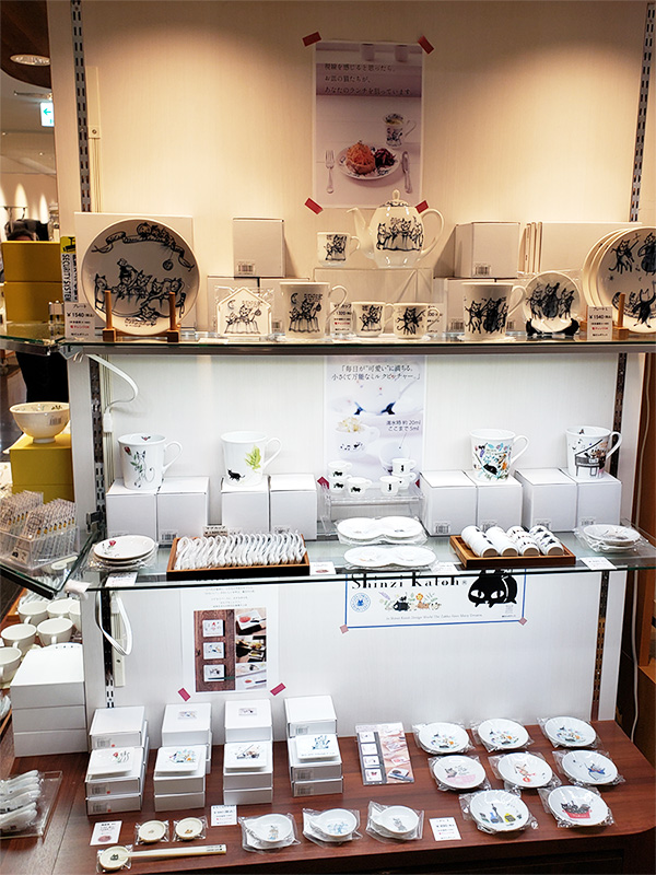 丸猫展の会場にずらりと並んだゼルポティエの什器。棚いっぱいに、世界的デザイナー・シンジカトウ氏が描く猫たちの食器やマグカップ、ポットが並び、猫好きさんにはたまらない賑やかな空間になっています。