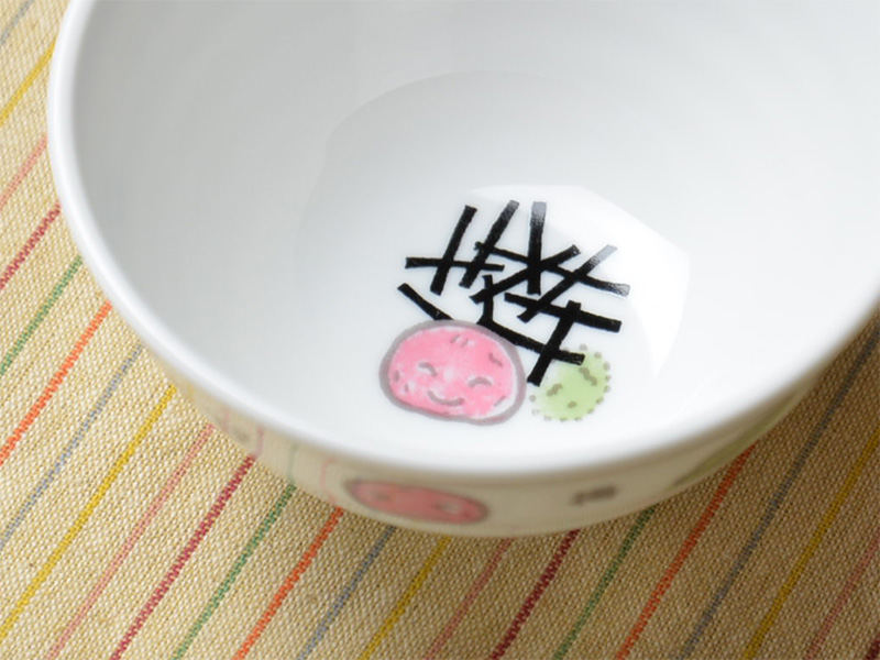 お茶碗の内側に描かれた梅茶漬けのイラスト。白いご飯の上に梅干し、海苔、あられ、わさびが乗った美味しそうな絵が、食べ終わる頃にひょっこり現れる遊び心あるデザイン。