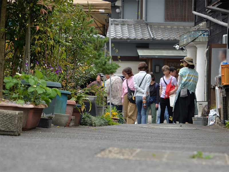【たじみ陶器まつり】オリベストリートへと続く、情緒あふれる黒壁の路地。左手の黒い土蔵造りの建物には、「本町オリベストリート」の白い案内看板が掲げられ、その奥へと続く細い道が来場者を誘っている。