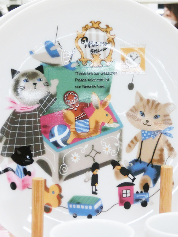 Designed by Shinzi Katoh（シンジカトウ）の猫柄プレート。白い陶磁器におもちゃ箱や猫たちが描かれた温かみのあるデザイン。